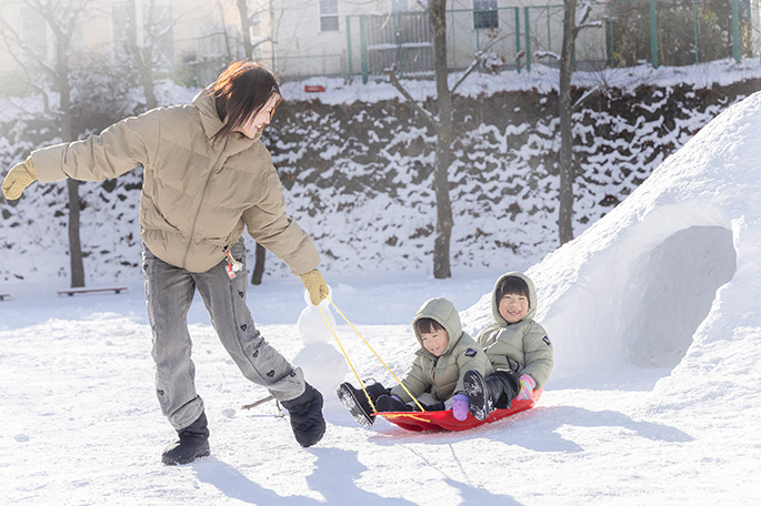 そり遊びをする親子
